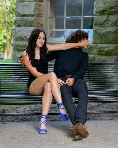 Two young people laughing together on a park bench during a family session in Delaware, Ohio